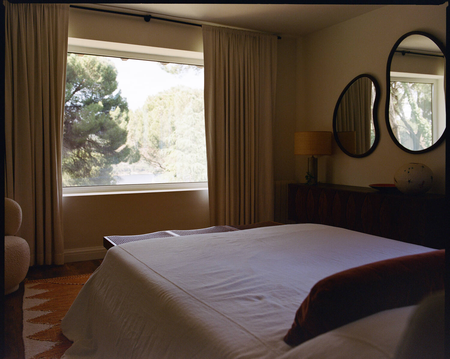 Bedroom with kidney-shaped mirrors and pine view