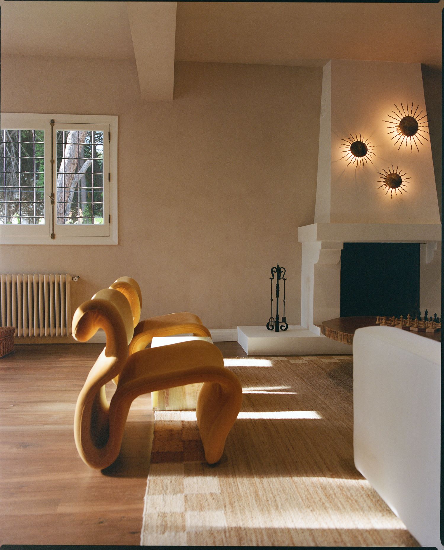 Living room with a sculptural wood bench and fireplace nook