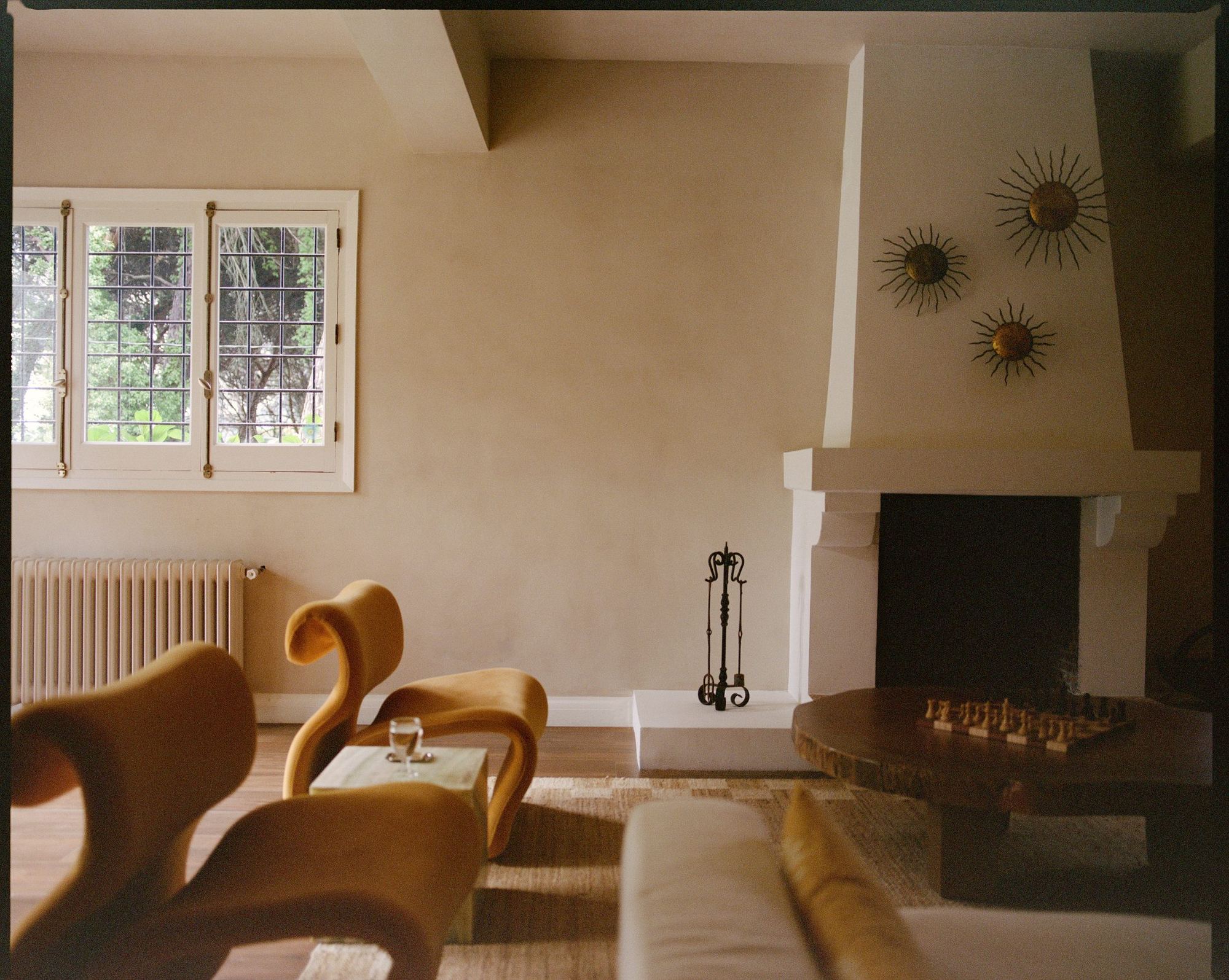 Lake House — living room with plaster fireplace and gilded sun mirrors