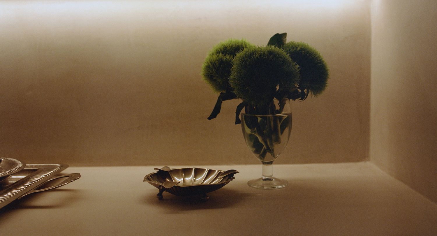 Green glass vase and bowls arranged on a console
