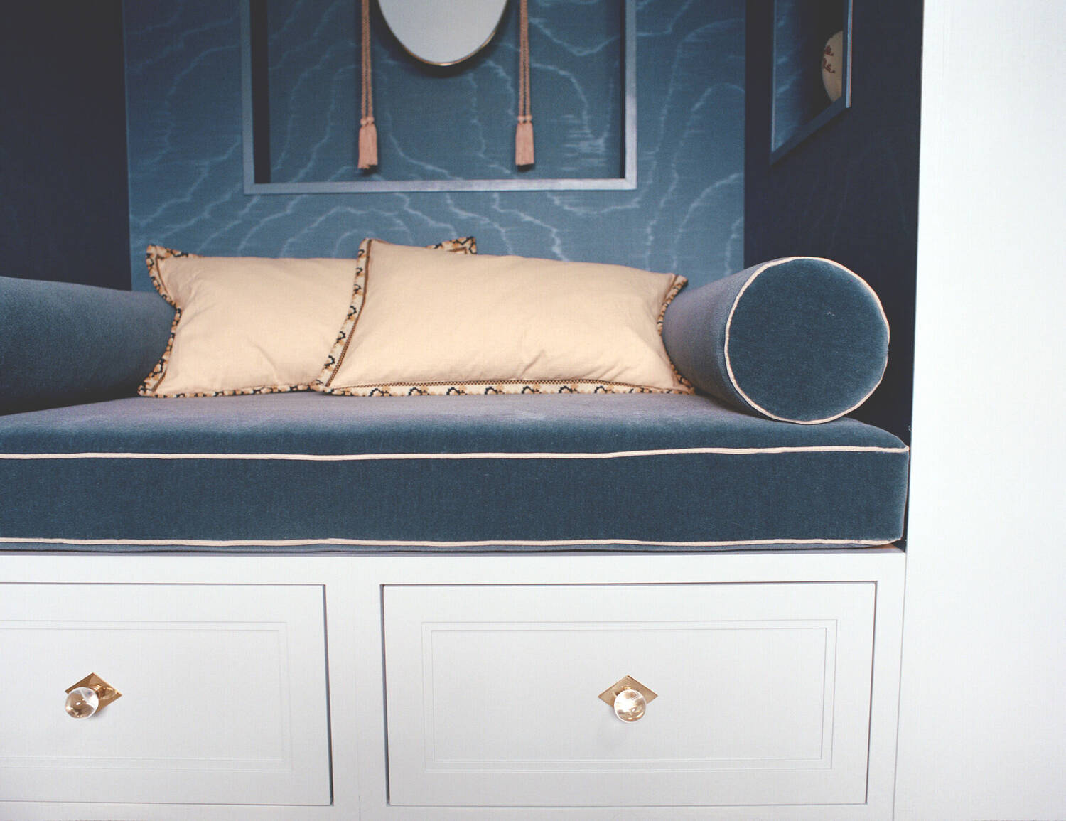Watermark-blue wall with oval mirror and silk tassels